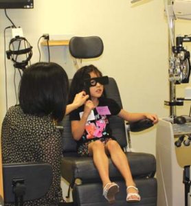 An RSO student administers an eye exam to an NISD student.