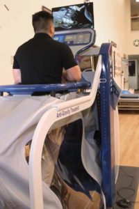  A PT student demonstrates an anti-gravity treadmill used to treat patients in the clinic.