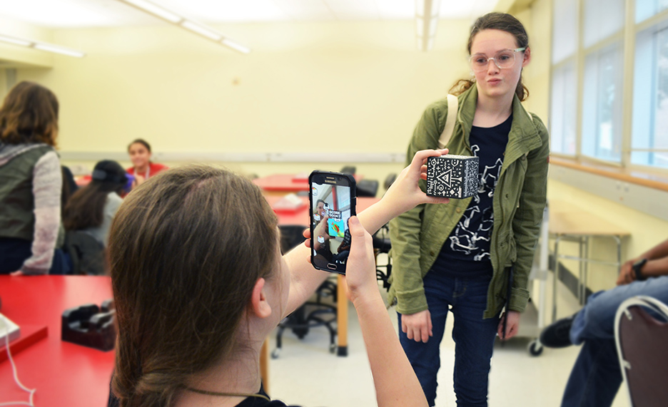 Two attendees explore augmented reality on mobile devices.