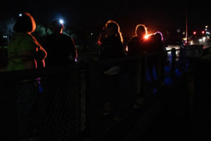 Students and staff gathered for the night's PIT Count. Silhouettes against a dark sky.