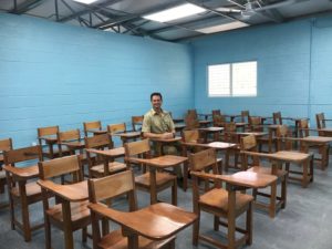 Speer takes a seat inside a classroom in Guatemala.